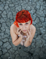 young woman with orange hair without clothes with transparent plastic by her body