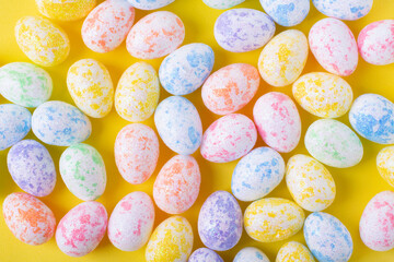 Fototapeta na wymiar Easter background with multicolored decorative eggs on yellow. Festive flat lay. Full frame