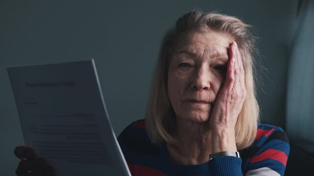 Worried elderly woman reading doctor report. . High quality 4k footage