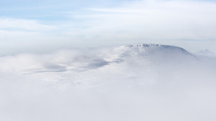view of a mountain above the clouds during holiday