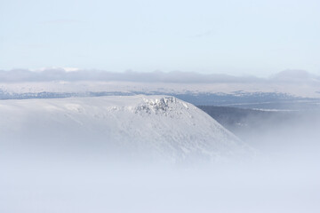 view of a mountain above the clouds during holiday