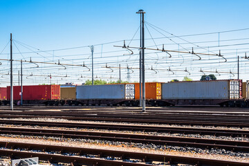 Fototapeta na wymiar Cargo trains loaded with containers in a freight terminal on a clear spring day