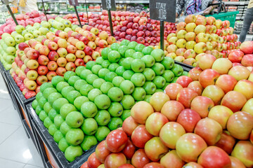 Different sorts of apples on the supermarket shelves in the fruit department