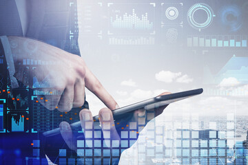 Businessman hand working with tablet device touching the screen by finger. Digital security and data storage concept in business process. Information icons flying in the air.