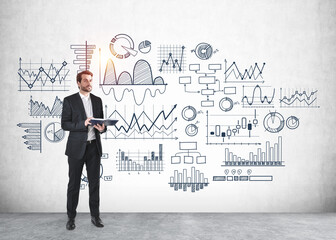 Businessman with notebook and graph sketch on the grey wall