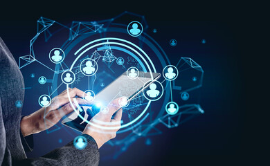 Businesswoman wearing formal suit is holding tablet in her hands