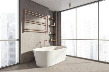 Bathroom interior with bathtub near window on concrete floor