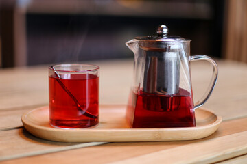Teapot with a cup of fruit hot tea and spoon