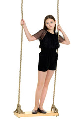 Joyful girl swinging on rope swing. Photo session in the studio