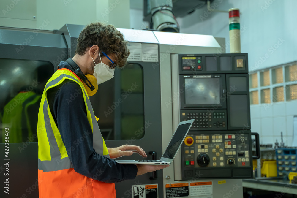 Poster professional technicians wears face mask standing and holding laptop with confident working at facto