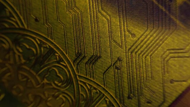 Background of a patterned embossed golden colored is glitters in a beam of light.  Macro. Closeup