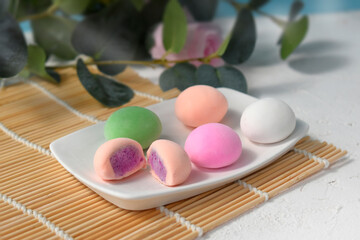 Colorful japanese dessert mochi with eucalyptus on table. Traditional healthy confectionery. Vegan sweets. Copyspace.
