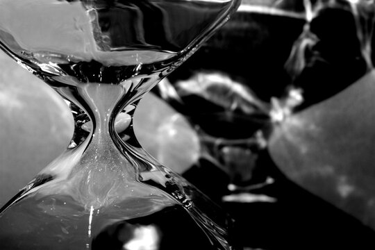Macro photography, detail of glass hourglass and shadows, black and white photo