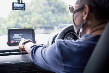 Driver using assistance comfortable for drive in Car Monitor LCD screen for camera maps or listening music view. New normal lifestyle Asian with masks prevent COVID-19 virus