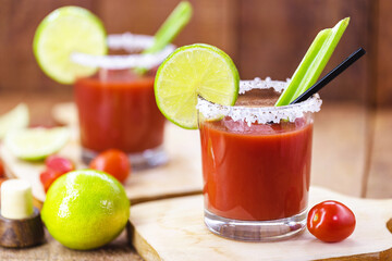 Canadian Caesar drink. Made with vodka, hot sauce and Worcestershire sauce, served with ice in a celery glass with a salted rim, decorated with a celery stalk and lemon slice