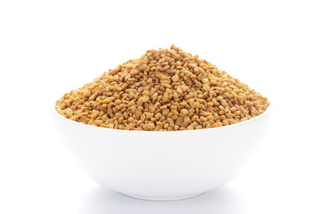 close-up of Organic Fenugreek seed (Trigonella foenum-graecum )  on a ceramic white bowl. Pile of Indian Aromatic Spice.