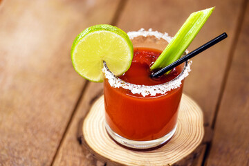 Canadian Caesar drink. Made with vodka, hot sauce and Worcestershire sauce, served with ice in a celery glass with a salted rim, decorated with a celery stalk and lemon slice