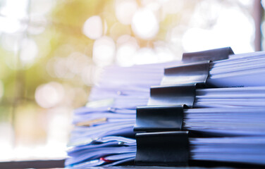 Piles of stack unfinished documents reports files with overwork paperwork on teacher desk. Messy...
