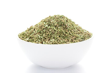 close-up of Organic Fennel Seeds (Foeniculum vulgare) Badi sonf on a ceramic white bowl. Pile of Indian Aromatic Spice.