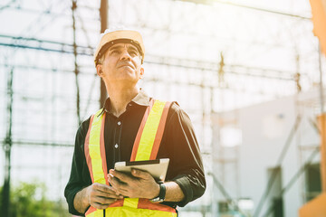 Foreman builder engineer worker looking at large building construction site sunny day hard work.