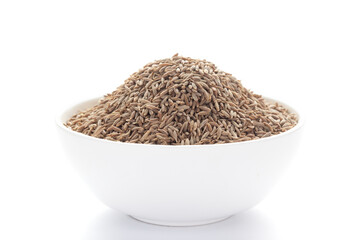 close-up of Organic cumin seed (Cuminum cyminum) or jeera on a ceramic white bowl. Pile of Indian Aromatic Spice.
