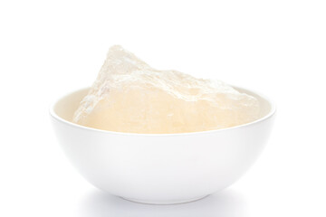 Close-up of coarse Fitkari ( potassium alum)  on white ceramic bowl. 