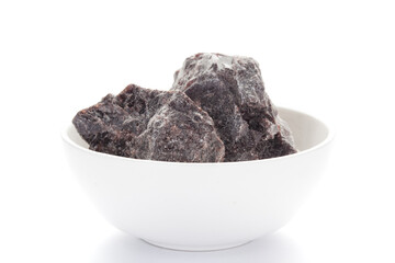 Close-up of coarse Himalayan Black  Salt (sodium chloride) edible on white ceramic bowl. 