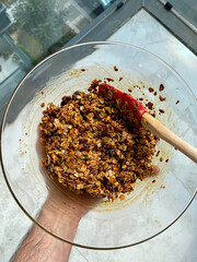 Homemade Baked Granola with Molasses Raisins and Nuts in Glass Bowl.