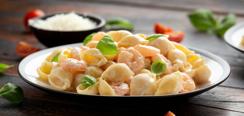 Italian conchiglie prawn, shrimp pasta in a creamy sauce on plate.