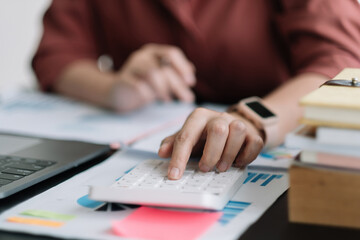 Business woman using calculator for do math finance on wooden desk in office, tax, accounting, statistics home accounring concept.
