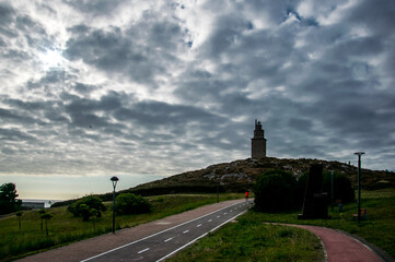 Bajo un manto de nubes de aspecto empedrado, un carril bici parece dirigirse hacia la torre de Hércules, el faro romano más antiguo y mejor conservado del mundo y situado en La Coruña, España