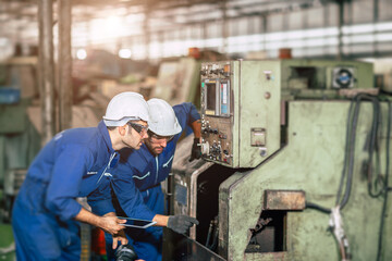 Fototapeta premium Engineer checking machine maintenance service with team working together teamwork in steel heavy factory