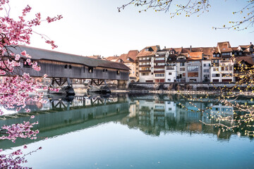 Büren an der Aare im Frühling, historische Altstadt mit Holzbrücke, Stadt gespiegelt im Fluss, Seeland, Kanton Bern, Schweiz