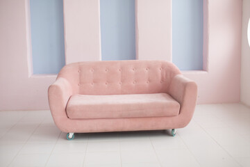 Pink sofa on a pink wall background 