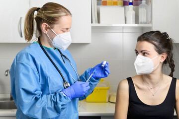 Young woman with protective face mask getting vaccinated, coronavirus concept. High quality photo