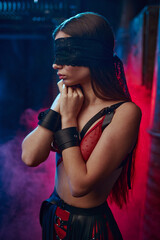 Sexy woman poses in bdsm blindfold and handcuffs