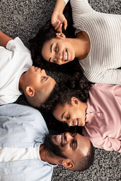 Portrait of black family lying on floor together