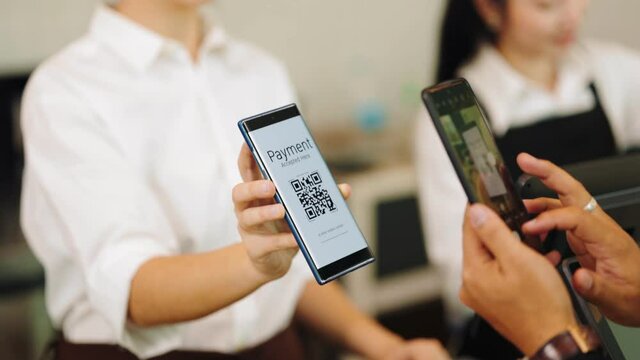 Customer paying with qr code on smartphone screen NFC payment technology at coffee shop.Midsection of female staff showing contactless menu QR code on digital mobile.