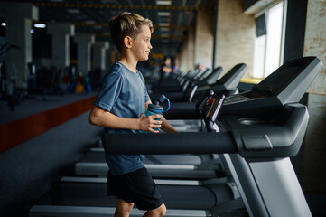 Boy doing exercise on treadmill, running machine