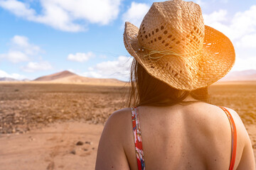 woman on a deserted road with red suitcase to go on a summer vacation
