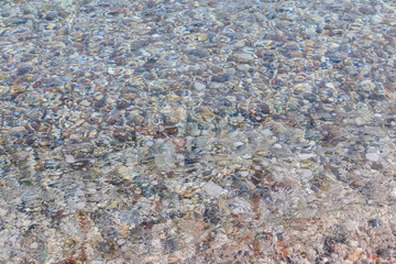 Background of a sea with a crystal clear water and pebbles on the bottom