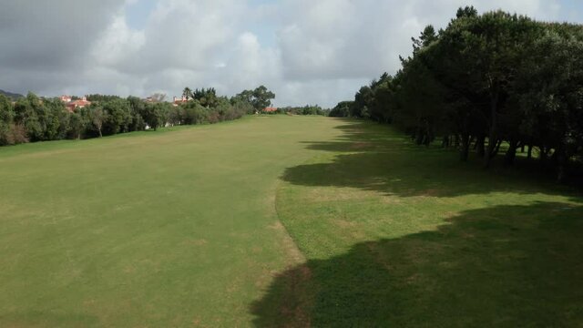 Aerial Backwards View Of Beautiful Green Lawn Of Gold Course. Empty Place With Sand Bunker During Sunlight.