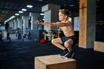 Fototapeta na wymiar Athletic boy doing balance exercise in gym