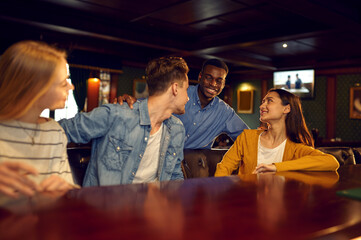 Smiling friends leisures at the counter in bar