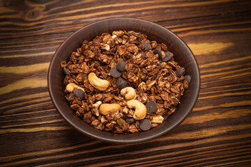 Chocolate granola cereal with nuts in a bowl.