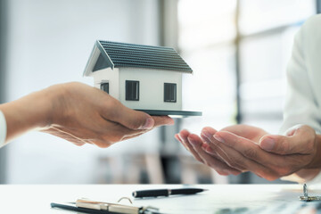 Property investment concept, image of small house model on the table. and home loan insurance. 