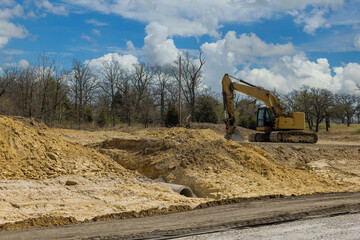 Construction of new road in a excavator digs and moving the ground