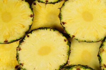 Pineapple juicy yellow slices background. Top view.