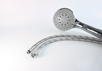 Shower head and flexible water connections on a light background. Plumbing accessories.