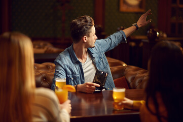 Male and female friends drinks alcohol in bar
